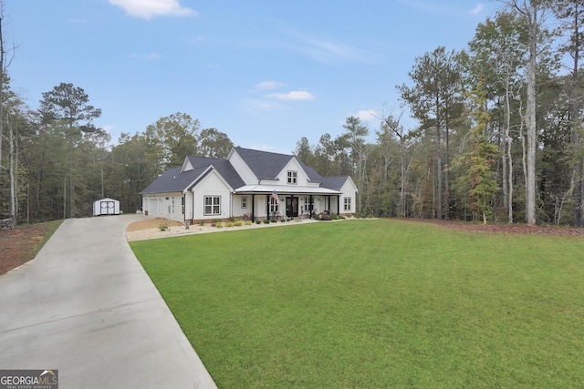 view of front facade featuring a porch, a storage unit, and a front lawn