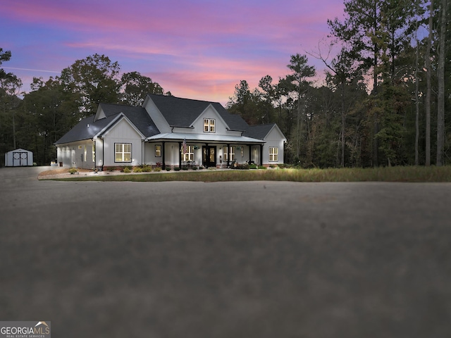 view of front of home featuring a shed and a porch