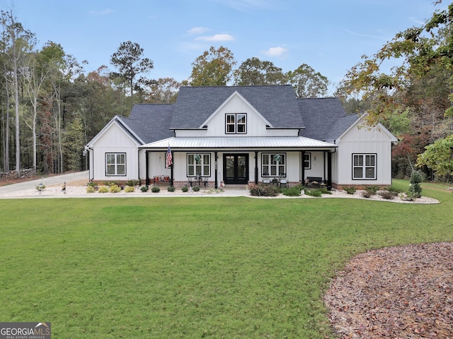 modern inspired farmhouse with a front yard and covered porch