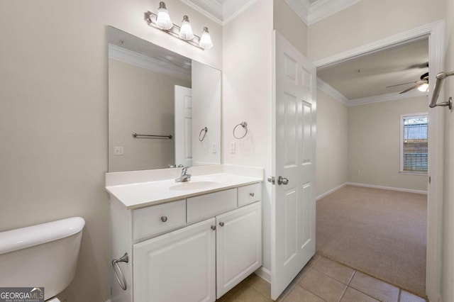 bathroom with toilet, crown molding, vanity, ceiling fan, and tile patterned flooring