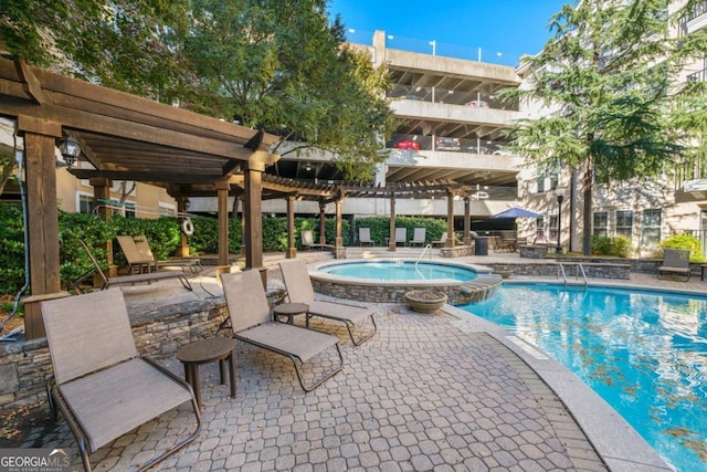 view of swimming pool featuring a hot tub, a pergola, and a patio