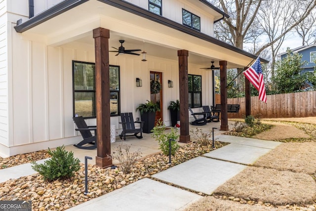 property entrance with covered porch, board and batten siding, fence, and a ceiling fan