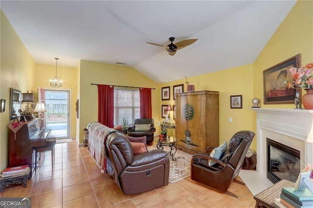 tiled living room with lofted ceiling and ceiling fan with notable chandelier