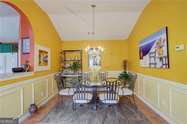 dining space featuring lofted ceiling and a notable chandelier