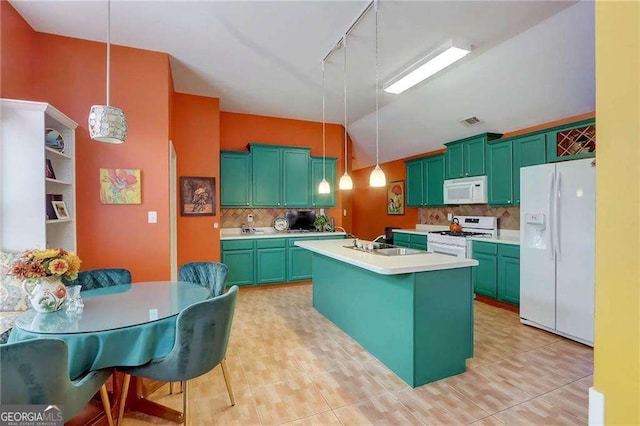 kitchen with pendant lighting, an island with sink, sink, decorative backsplash, and white appliances