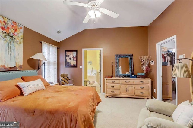 bedroom with lofted ceiling, ensuite bath, ceiling fan, light carpet, and a spacious closet