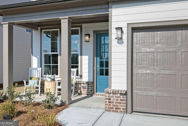 doorway to property featuring a garage and covered porch