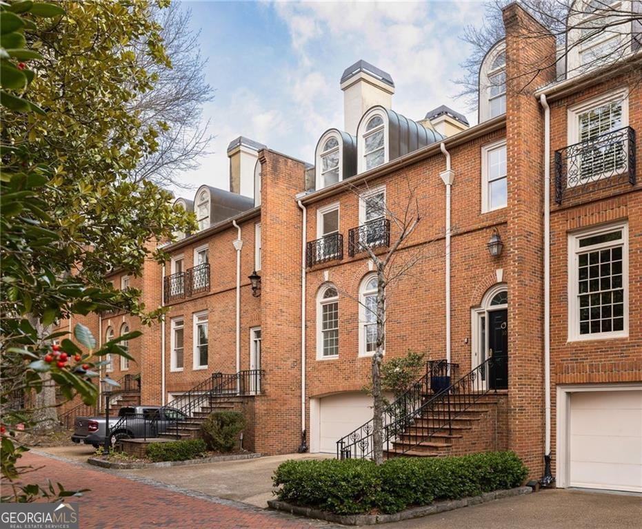 view of front facade featuring brick siding, driveway, and an attached garage