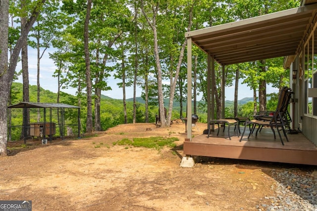 view of yard with a deck with mountain view