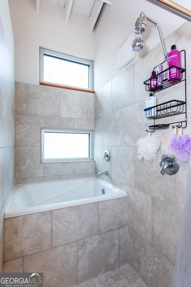 1661 La France St NE Unit 216, Atlanta, GA 30307 - bathroom with healthy amount of natural light, a relaxing tiled tub, tiled shower, tile walls, and beam ceiling