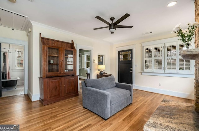 living area featuring crown molding, ceiling fan, and hardwood / wood-style floors