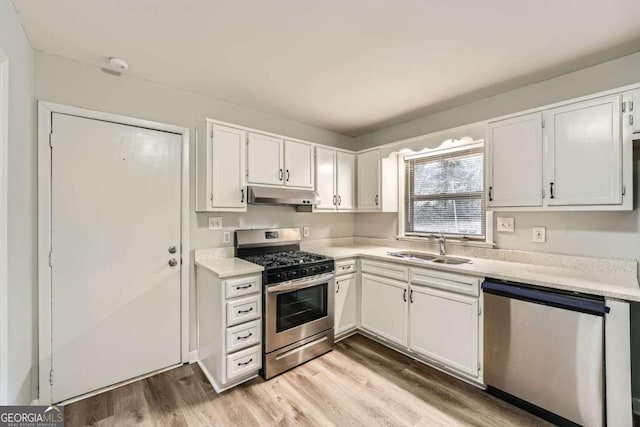 kitchen with white cabinetry, sink, light hardwood / wood-style floors, and appliances with stainless steel finishes