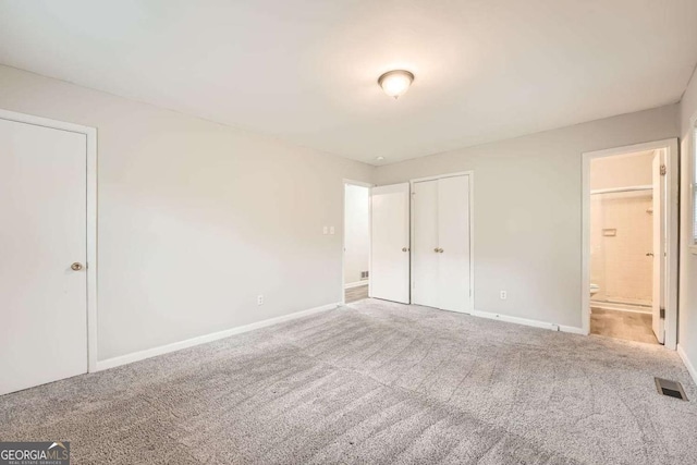 unfurnished bedroom featuring a closet, connected bathroom, and carpet