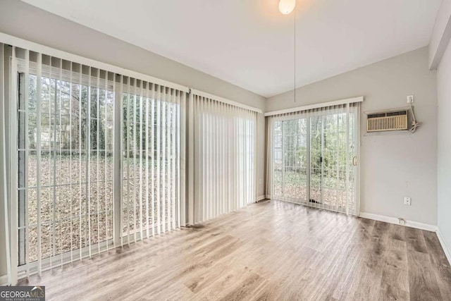 interior space featuring hardwood / wood-style flooring and an AC wall unit