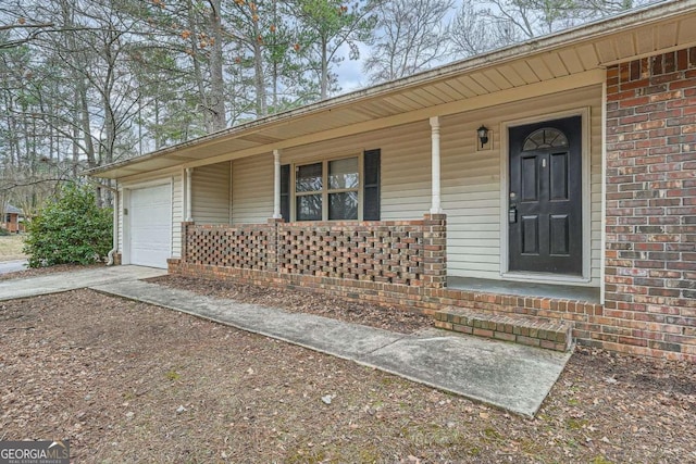 doorway to property featuring a garage and a porch