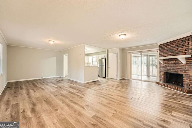 unfurnished living room with crown molding, a fireplace, light hardwood / wood-style flooring, and a textured ceiling