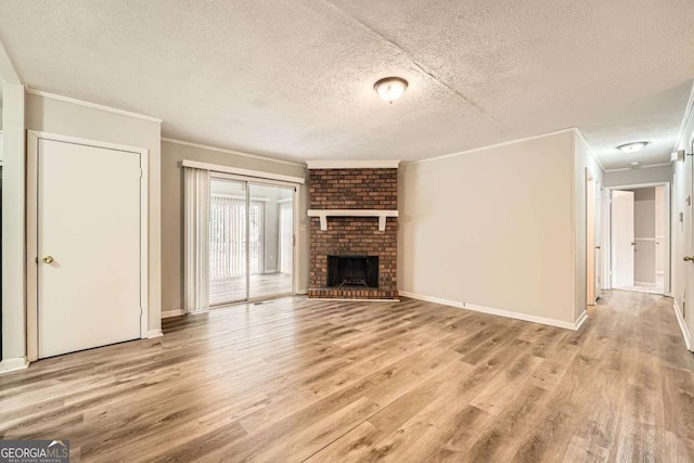 unfurnished living room featuring ornamental molding, a fireplace, light hardwood / wood-style floors, and a textured ceiling