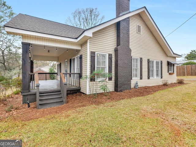 view of side of property with a yard and a porch