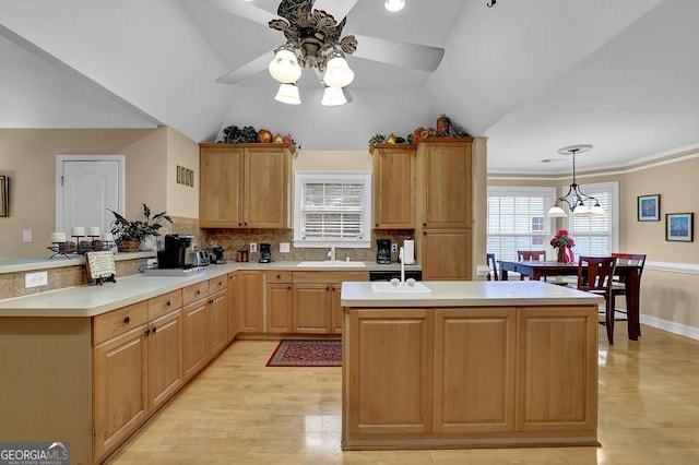 kitchen with hanging light fixtures, tasteful backsplash, light hardwood / wood-style flooring, and kitchen peninsula