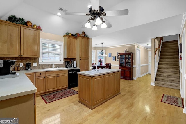 kitchen with lofted ceiling, sink, a center island, hanging light fixtures, and dishwasher