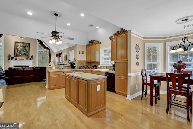 kitchen featuring black dishwasher, a center island, light hardwood / wood-style floors, and kitchen peninsula