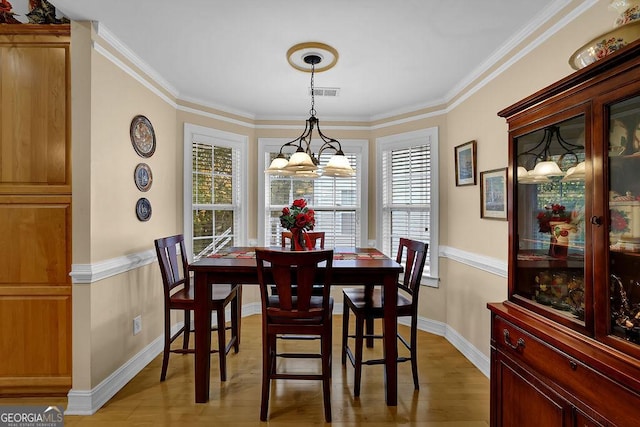 dining area featuring ornamental molding and wood-type flooring