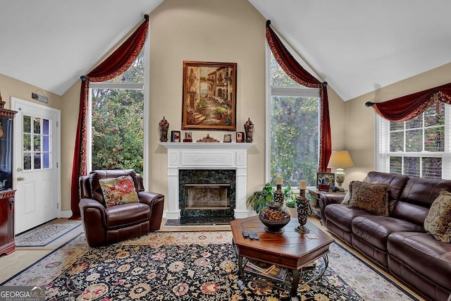 living room with vaulted ceiling and a high end fireplace