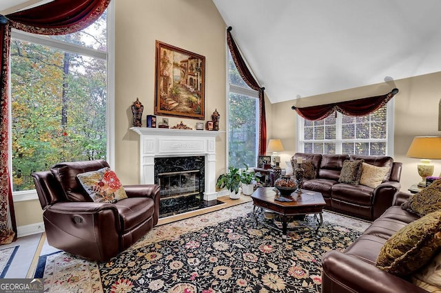 living room featuring lofted ceiling and a high end fireplace