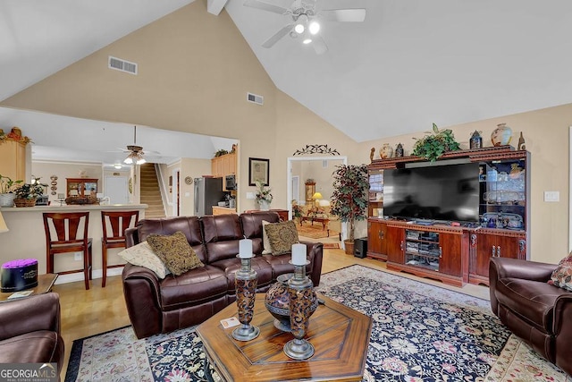 living room with ceiling fan, lofted ceiling, and light wood-type flooring