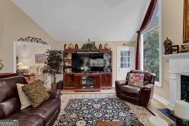 living room featuring a premium fireplace and vaulted ceiling