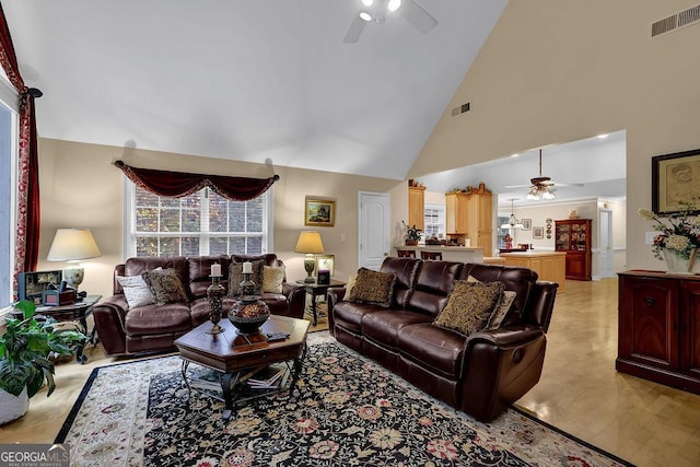 living room with high vaulted ceiling, ceiling fan, and light hardwood / wood-style flooring