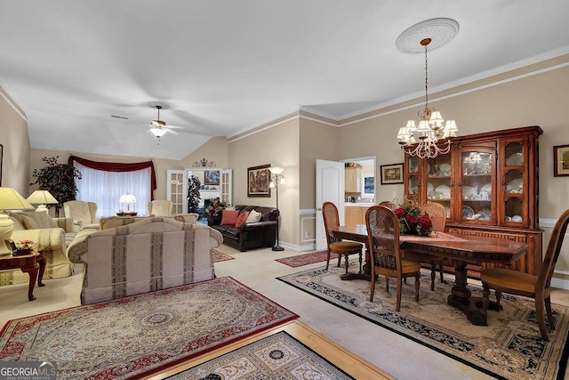 dining area with vaulted ceiling, ornamental molding, and ceiling fan with notable chandelier