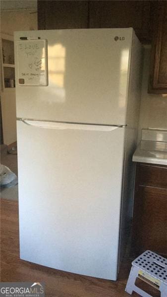 details with white fridge and dark brown cabinetry