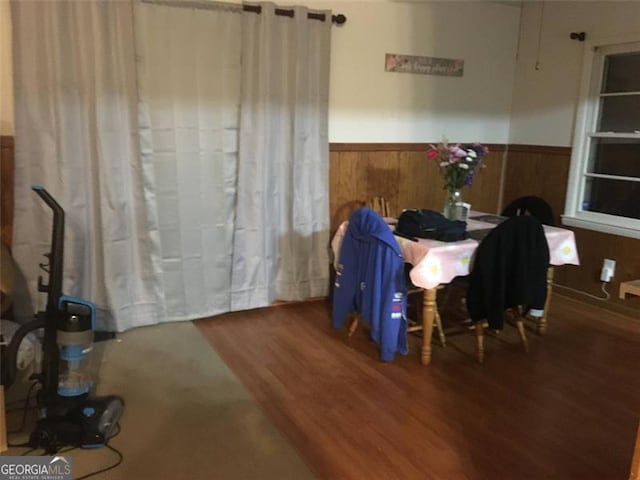 dining room featuring wood-type flooring and wood walls