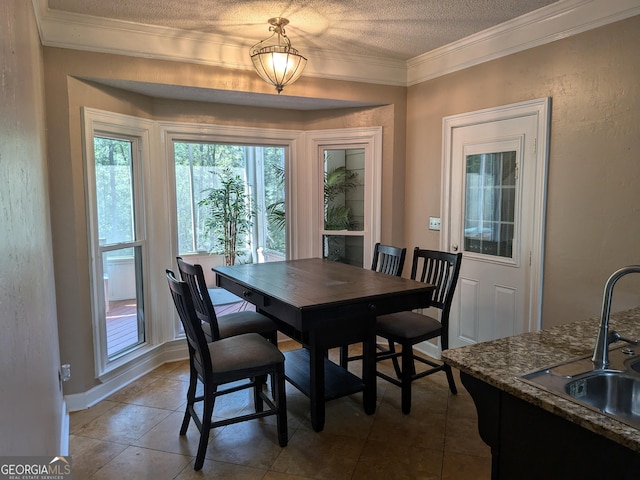 dining room featuring tile patterned flooring, ornamental molding, sink, and a textured ceiling