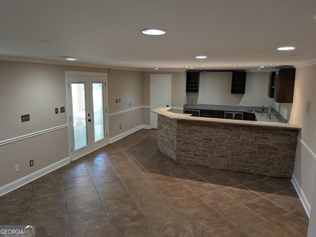 kitchen with sink, crown molding, french doors, and dark tile patterned flooring