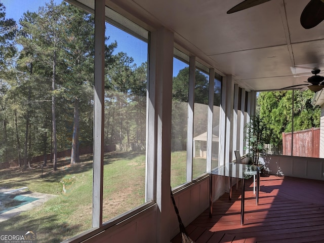 unfurnished sunroom with ceiling fan