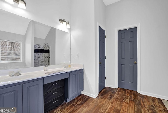 bathroom featuring a shower with curtain, wood-type flooring, vaulted ceiling, and vanity