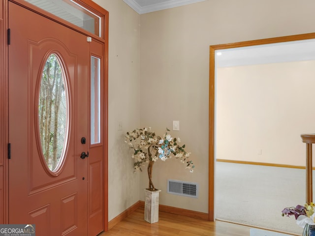 entryway featuring ornamental molding and light hardwood / wood-style flooring