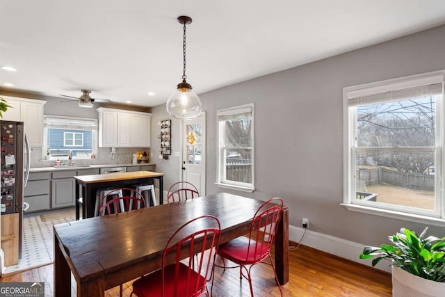 dining space featuring ceiling fan, sink, and light hardwood / wood-style flooring