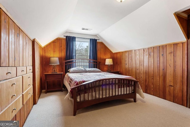 bedroom featuring lofted ceiling, light carpet, and wood walls