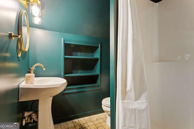 bathroom featuring curtained shower and toilet