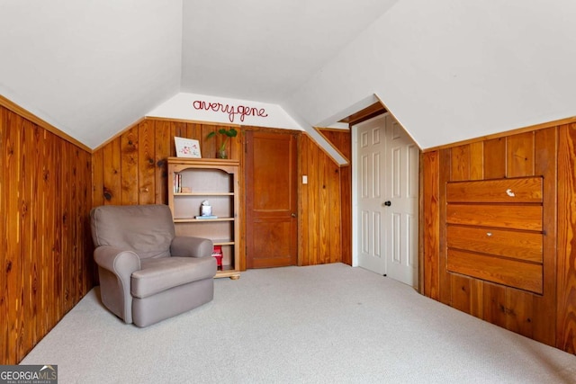 living area with lofted ceiling, carpet floors, and wooden walls