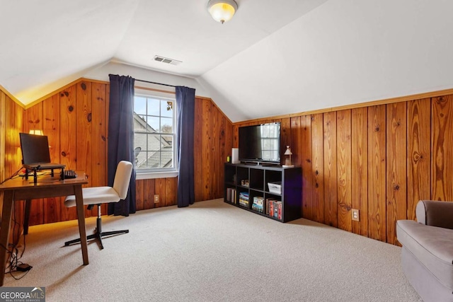 office featuring vaulted ceiling, carpet, and wood walls