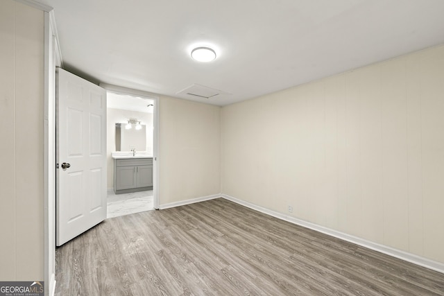 empty room featuring sink and light hardwood / wood-style floors