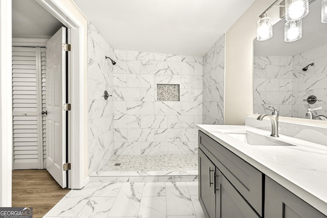 bathroom with vanity and tiled shower