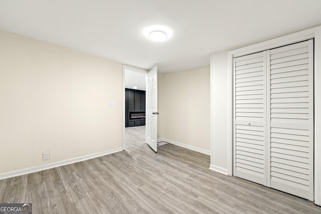 unfurnished bedroom featuring a closet and light wood-type flooring