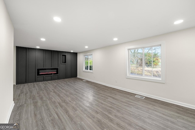 unfurnished living room with hardwood / wood-style flooring and a fireplace