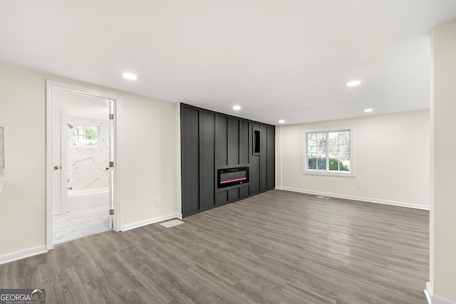 unfurnished living room with hardwood / wood-style flooring, plenty of natural light, and a fireplace