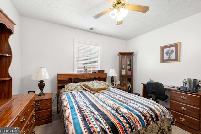 carpeted bedroom with ceiling fan and a textured ceiling